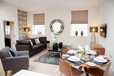 a living room with a table and a couch at The Halston Carlisle in Carlisle