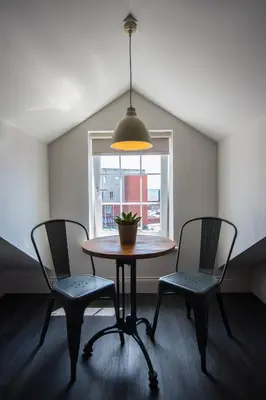 a table and two chairs in a room with a window at The Halston Carlisle in Carlisle