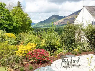 a patio with chairs and flowers in a garden at 4 Bed in Keswick SZ267 in Keswick
