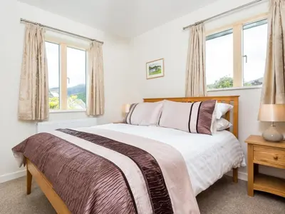 a bedroom with a bed and two windows at 4 Bed in Keswick SZ267 in Keswick