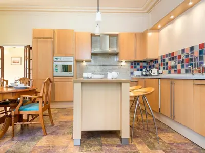 a kitchen with wooden cabinets and a table and chairs at 3 Bed in Applethwaite SZ168 in Applethwaite