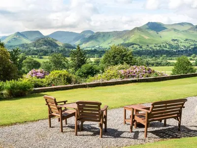 three benches and a table with mountains in the background at 3 Bed in Applethwaite SZ168 in Applethwaite