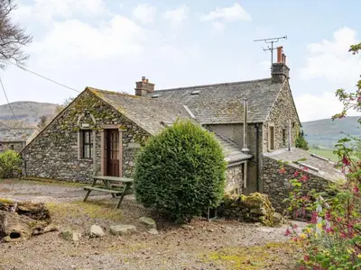 an old stone cottage with a picnic bench in front of it at 1 Bed in Penrith oc-sz295 in Dockray