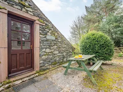 a picnic table in front of a stone building with a door at 1 Bed in Penrith oc-sz295 in Dockray