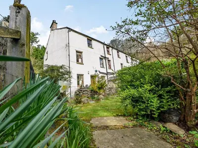 an old white house in the middle of a garden at 3 Bed in Keswick oc-sz065 in Applethwaite