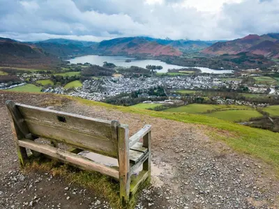 a bench sitting on top of a hill overlooking a city at 2 Bed in Bassenthwaite SZ381 in Bassenthwaite Lake