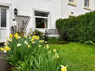 a bench in front of a house with flowers at 3 Bed in Keswick SZ547 in Keswick