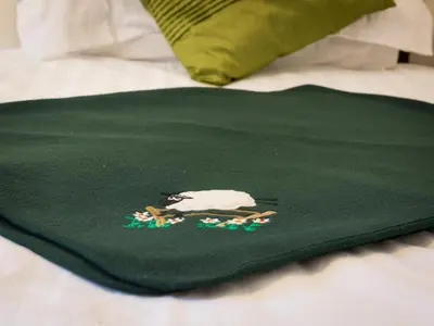 a green blanket with a cow on a bed at 3 Bed in Keswick SZ547 in Keswick