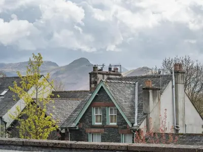 an old house with mountains in the background at 2 Bed in Keswick oc-sz490 in Keswick