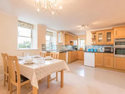 a kitchen with a table with chairs and a table and a table at 2 Bed in Keswick oc-sz490 in Keswick