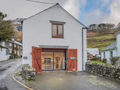a white house with brown doors on a street at 3 Bed in Borrowdale SZ465 in Rosthwaite