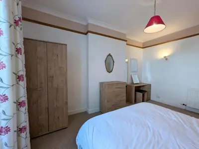 a bedroom with a white bed and a wooden cabinet at 3 Bed in Keswick SZ187 in Keswick