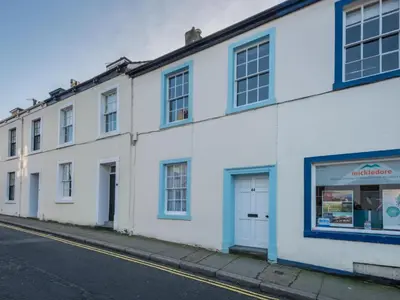 a white building with blue windows on a street at 3 Bed in Keswick SZ187 in Keswick