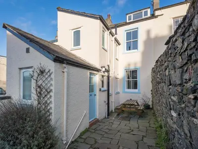 a white house with a blue door and a stone wall at 3 Bed in Keswick SZ187 in Keswick