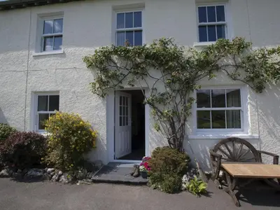 a white house with a wooden table and a bench at 3 Bed in Newlands Valley SZ075 in Borrowdale Valley