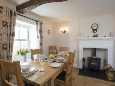 a dining room with a table and a fireplace at 3 Bed in Newlands Valley SZ075 in Borrowdale Valley