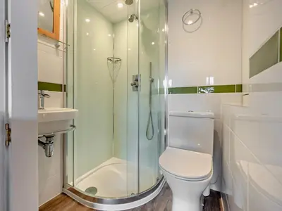 a bathroom with a shower and a toilet and a sink at 1 Bed in Keswick SZ472 in Keswick