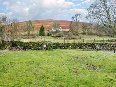 a field of grass with a hill in the background at 2 Bed in Penrith oc-sz339 in Watermillock