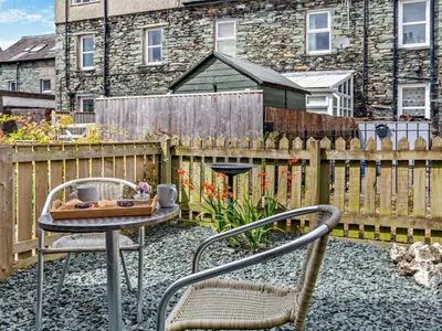 a patio with two chairs and a table and a fence at 2 Bed in Keswick oc-sz026 in Keswick