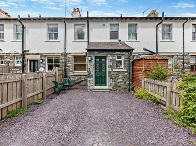 a stone house with a green door and a fence at 2 Bed in Keswick oc-sz026 in Keswick