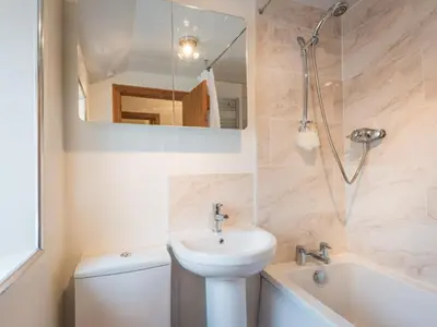 a bathroom with a sink and a toilet and a mirror at 3 Bed in Gosforth oc-sz064 in Gosforth