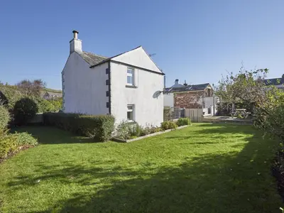 a white house with a yard with green grass at 3 Bed in Gosforth oc-sz064 in Gosforth