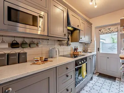a kitchen with white cabinets and a stove top oven at 1 Bed in Keswick oc-sz112 in Keswick