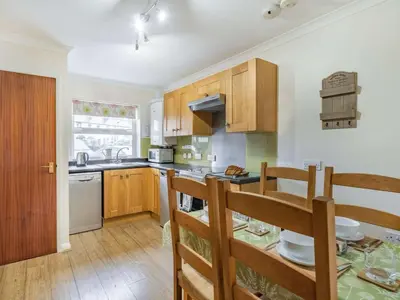 a kitchen with wooden cabinets and a table with chairs at 2 Bed in Keswick SZ462 in Keswick