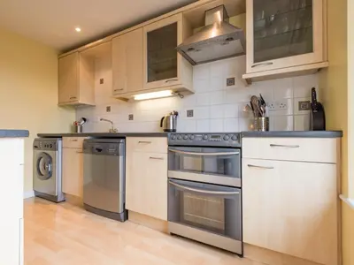 a kitchen with wooden cabinets and stainless steel appliances at 3 Bed in Applethwaite SZ540 in Applethwaite