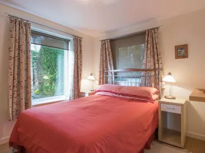 a bedroom with a red bed and a window at 3 Bed in Applethwaite SZ540 in Applethwaite