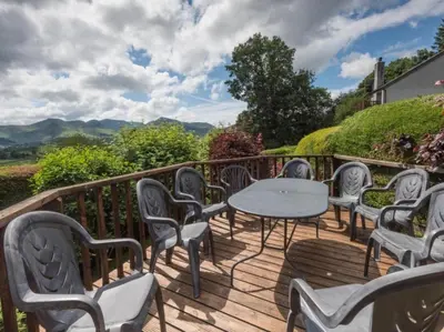 a wooden deck with chairs and a table on it at 3 Bed in Applethwaite SZ540 in Applethwaite