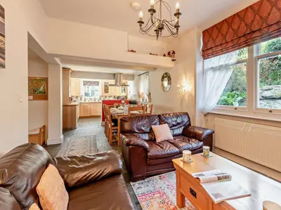a living room with leather furniture and a kitchen at 4 Bed in Keswick SZ292 in Keswick