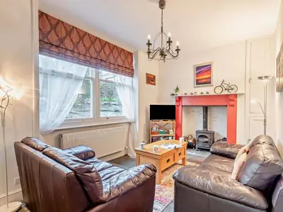 a living room with two leather couches and a fireplace at 4 Bed in Keswick SZ292 in Keswick