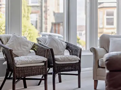 two wicker chairs with pillows in a room with windows at 4 Bed in Keswick SZ292 in Keswick