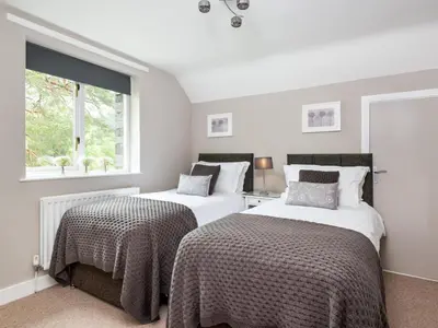 a bedroom with two beds and a window at 4 Bed in Keswick oc-sz219 in Grange