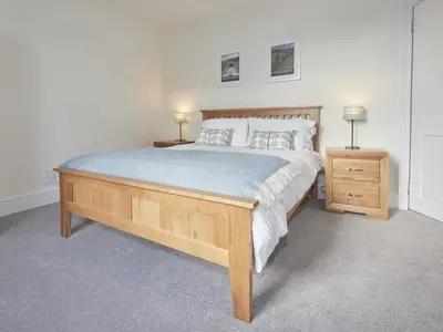a bedroom with a large bed and a nightstand with two lamps at 4 Bed in Keswick oc-sz443 in Keswick