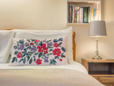 a bed with a pillow with flowers on it at 3 Bed in Keswick oc-sz194 in Braithwaite