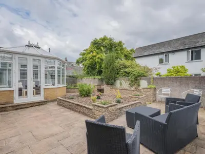 a patio with chairs and a garden and a house at 3 Bed in Keswick oc-sz283 in Keswick