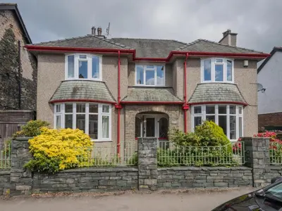 a house with a stone fence in front of it at 3 Bed in Keswick oc-sz283 in Keswick