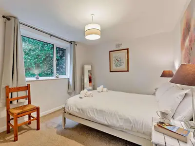 a bedroom with a bed and a chair and a window at 2 Bed in Wasdale oc-sz077 in Santon Bridge