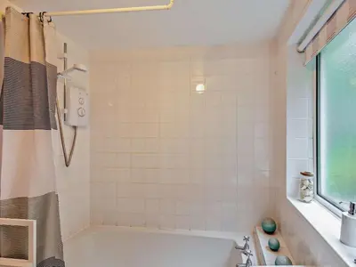 a white bathroom with a tub and a shower at 2 Bed in Wasdale oc-sz077 in Santon Bridge