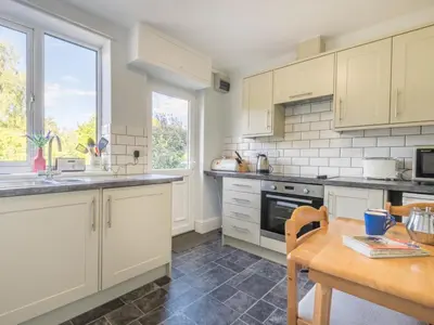 a kitchen with white cabinets and a wooden table at 3 Bed in Braithwaite SZ045 in Braithwaite