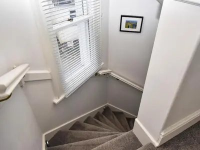 a winding staircase with a window in a stair case at 3 Bed in Keswick oc-sz118 in Keswick