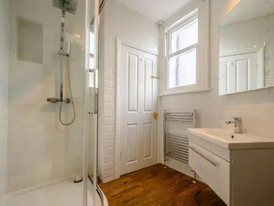 a bathroom with a shower and a sink and a window at 3 Bed in Keswick oc-sz118 in Keswick