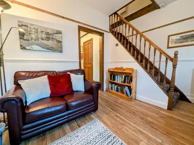 a leather couch in a living room with a staircase at 2 Bed in Keswick oc-sz417 in Keswick