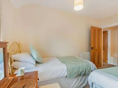 a bedroom with two beds and a wooden table at 3 Bed in Keswick oc-sz153 in Braithwaite