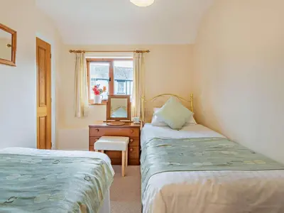a bedroom with two beds and a desk with a mirror at 3 Bed in Keswick oc-sz153 in Braithwaite