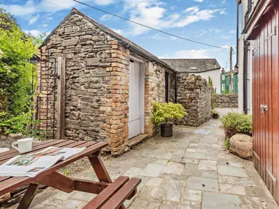a picnic table in front of a stone building at 3 Bed in Keswick oc-sz153 in Braithwaite