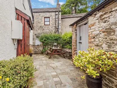 a patio with a wooden door and a table next to a building at 3 Bed in Keswick oc-sz153 in Braithwaite