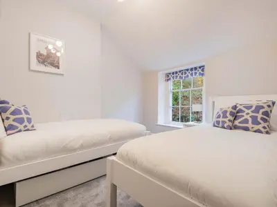 a white bedroom with two beds and a window at 2 Bed in Glenridding SZ178 in Glenridding